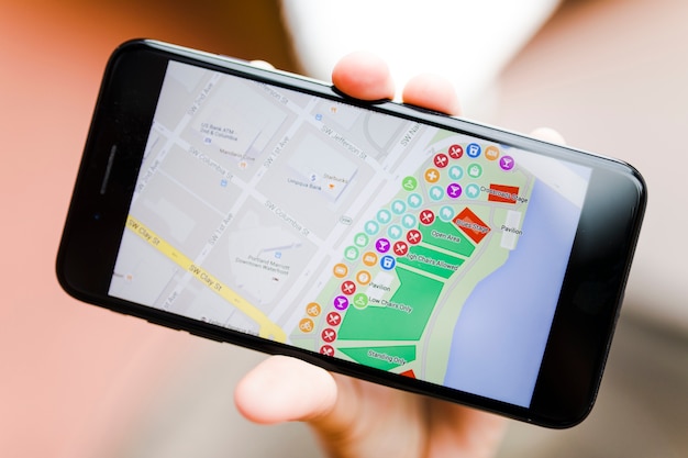 Free Photo close-up of a person's hand holding smartphone with map gps navigation