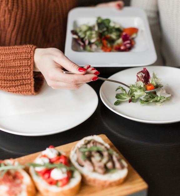 Free photo close-up person serving delicious salad