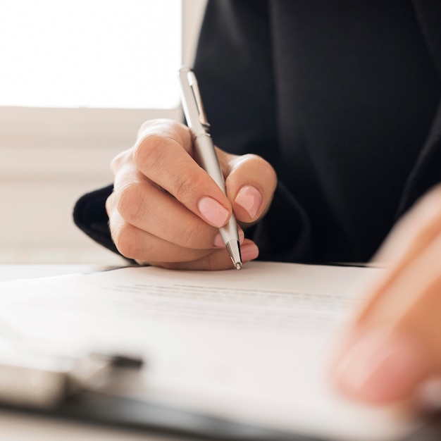 Close-up person signing a certificate