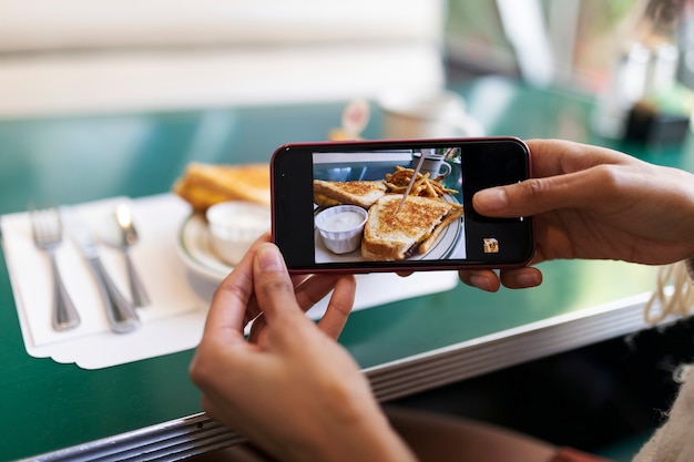 Free photo close up on person taking photo of food