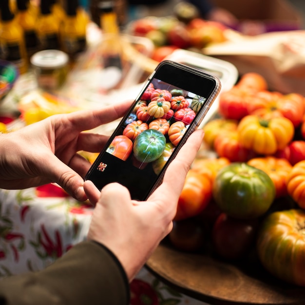 Free Photo close-up person taking a picture of vegetables