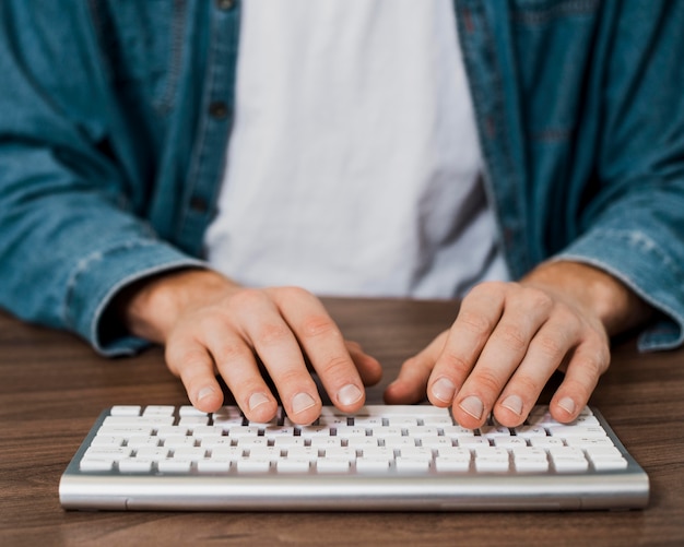 Free photo close-up person using a wireless mac keyboard