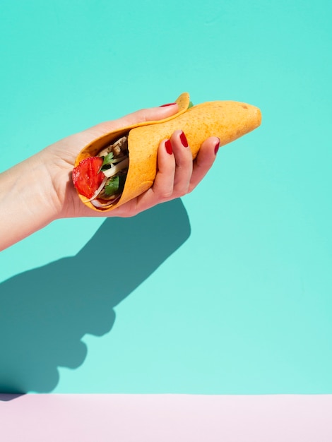 Free Photo close-up person with burrito and blue background