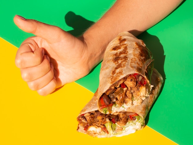 Free Photo close-up person with burrito showing approval