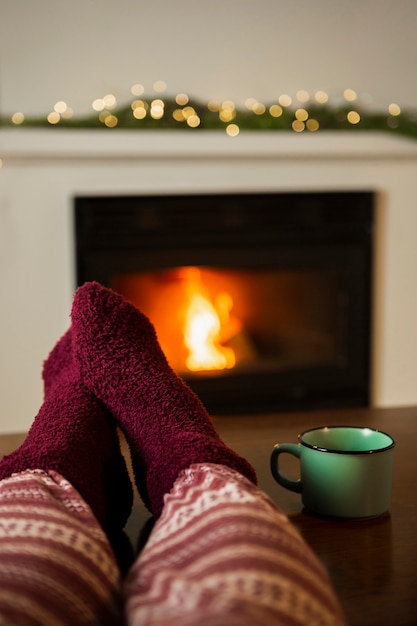 Free Photo close-up person with cozy socks near the fireplace