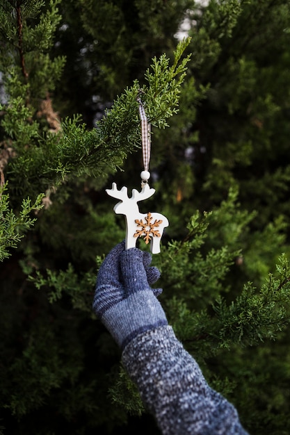 Free photo close-up person with gloves holding reindeer shaped decoration