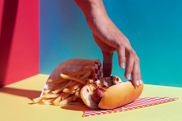 Free Photo close-up person with hot dog and fries