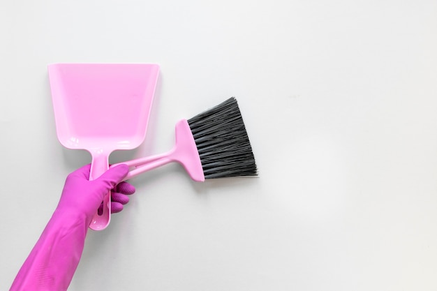 Close-up person with purple gloves holding small broom