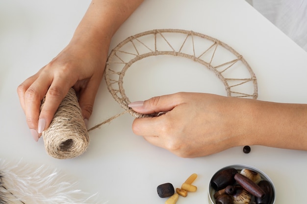 Free photo close up on person working on dreamcatcher