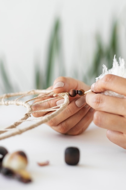 Close up on person working on dreamcatcher