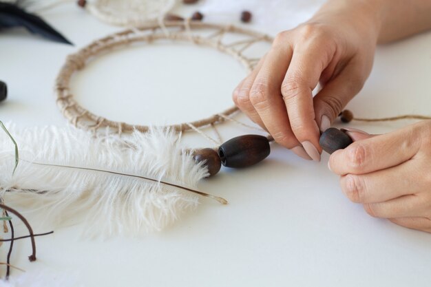 Close up on person working on dreamcatcher