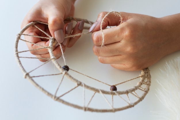 Free photo close up on person working on dreamcatcher