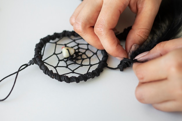 Close up on person working on dreamcatcher