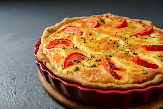 Close-up photo of classic quiche lorraine pie with tomatoes