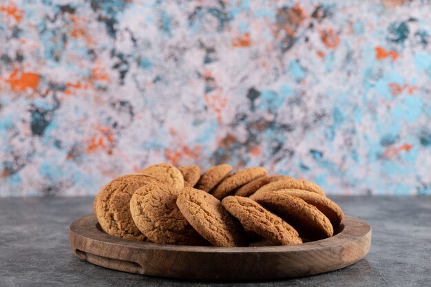 Close up photo of fresh homemade cookies on wooden tray. Delicious snack. 