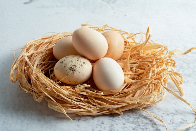 Free photo close up photo of fresh organic chicken eggs on straw.