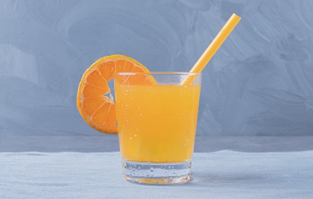 Free photo close up photo of freshly made orange juice on grey background.