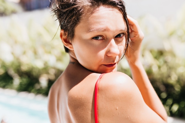 Free Photo close-up photo of inspired tanned woman looking over shoulder.