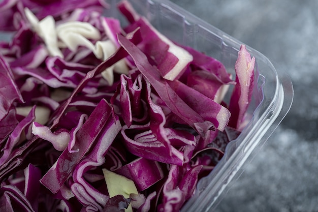 Close up photo of plastic container full with chopped purple cabbage. Macro photo . 