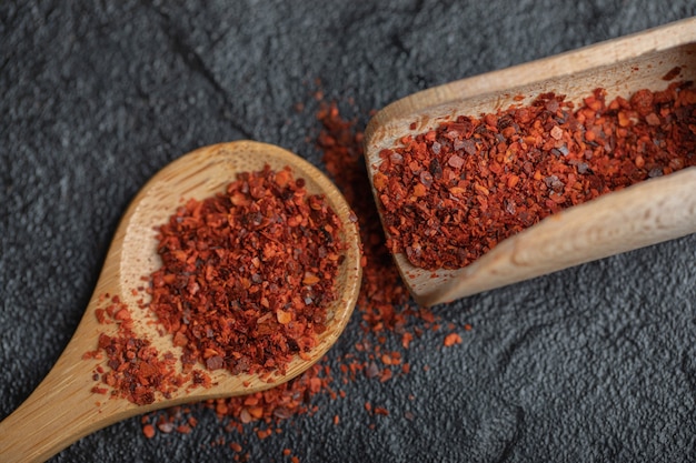 Free Photo close up photo of red hot chili pepper with wooden spoons on black background.