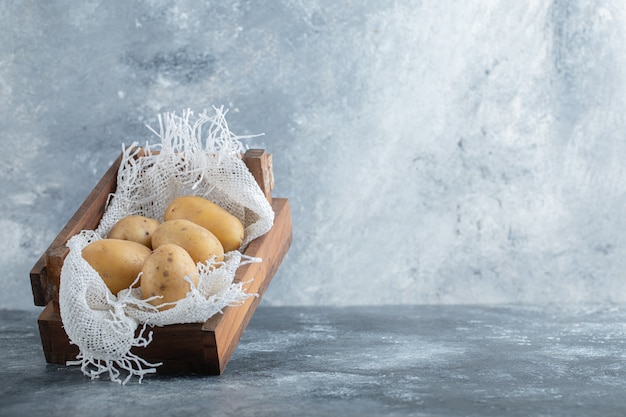 Free photo close up photo of ripe potatoes in wooden basket over grey background