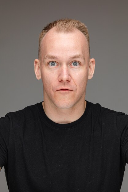 Close-up photo of surprised Caucasian man in black shirt