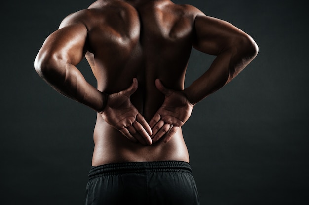 Free photo close-up photo of young african sports man feeling pain in his back