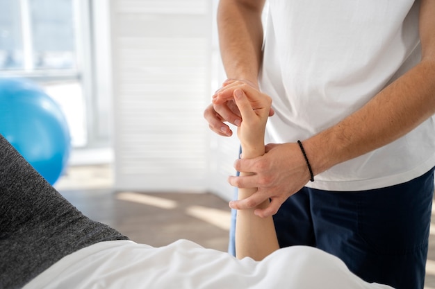 Close up physiotherapist helping patient