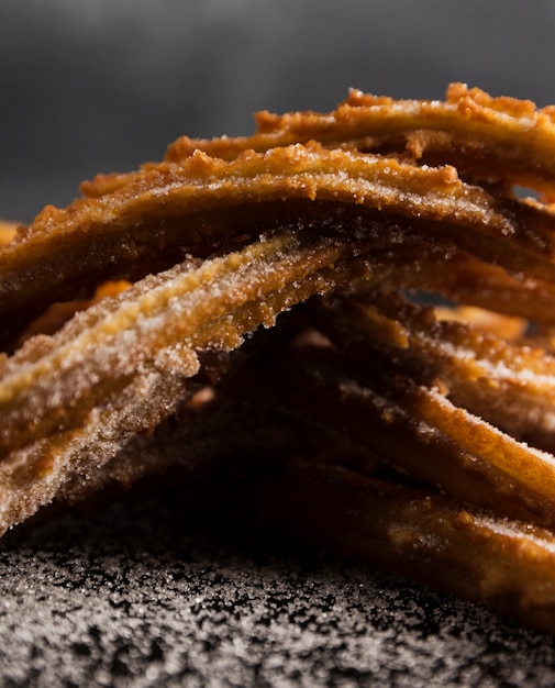 Free photo close-up pile of fried churros and sugar