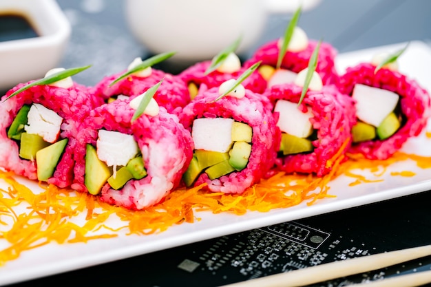 Free Photo close up of pink sushi rolls with crab sticks avocado and bell pepper