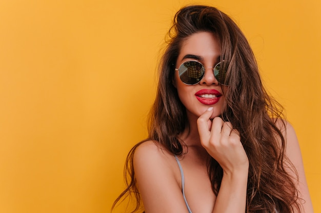 Close-up portrait of adorable brown-haired girl posing with interested smile