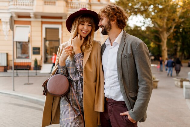 Free Photo close up portrait of amazing stylish couple in love spending romantic holidays in european city. pretty blond woman in hat and casual dress smiling and looking on her handsome man with beard.