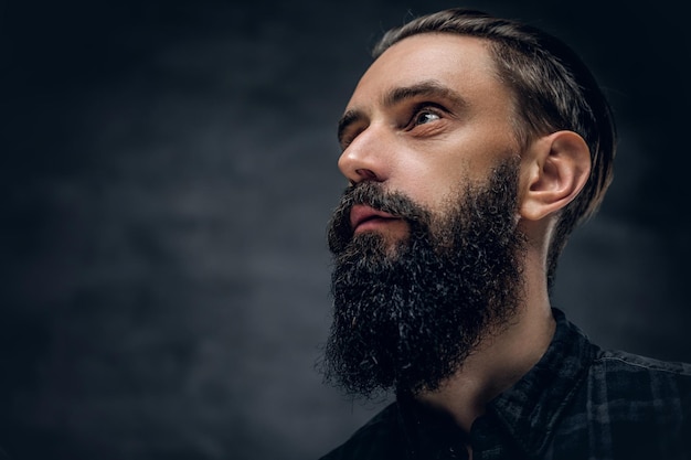 Free photo close up portrait of bearded male looking up on a dark background.