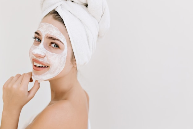 Close-up portrait of beautiful young woman with towels after take bath make cosmetic mask on her face.