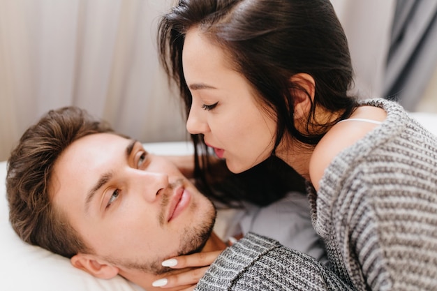 Free photo close-up portrait of black-haired lady with white manicure looking with love at her husband