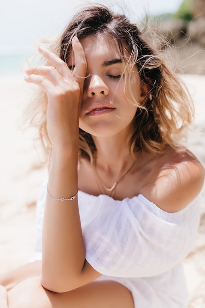 Free Photo close-up portrait of caucasian beautiful carefree woman posing on nature. gorgeous blonde woman chilling at beach with eyes closed.