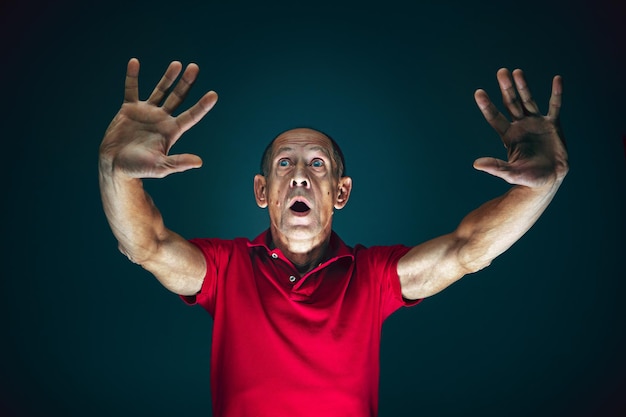 Free photo close up portrait of crazy scared and shocked man isolated on dark