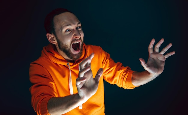 Free photo close up portrait of crazy scared and shocked man isolated on dark