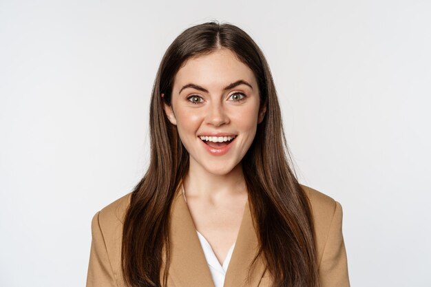 Close up portrait of enthusiastic corporate woman looking amazed and excited at camera standing in s...