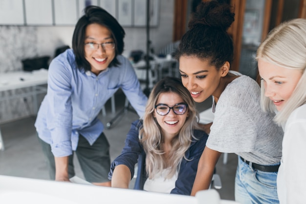 Close-up portrait of freelance it-specialists looking at laptop screen with smile