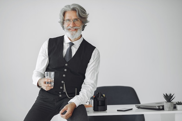 Free photo close up portrait of grinning old-fashioned man.  grandfather with glass of water.