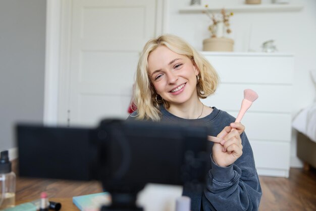 Free Photo close up portrait of happy young beauty blogger records lifestyle vlog in her room using camera with