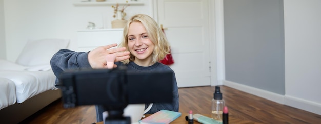 Free photo close up portrait of happy young beauty blogger records lifestyle vlog in her room using camera with