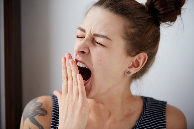 Free Photo close up portrait headshot sleepy young woman with wide open mouth yawning