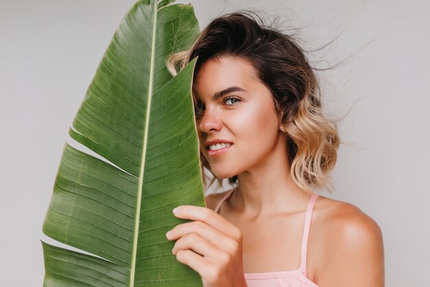 Close-up portrait of interested woman with shiny tanned skin looking. happy caucasian girl with short wavy hair isolated.