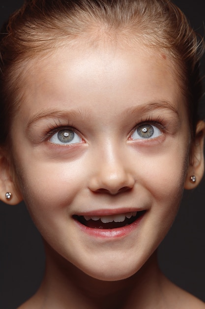 Free photo close up portrait of little and emotional caucasian girl. highly detail photoshoot of female model with well-kept skin and bright facial expression. concept of human emotions. dreaming, looking up.