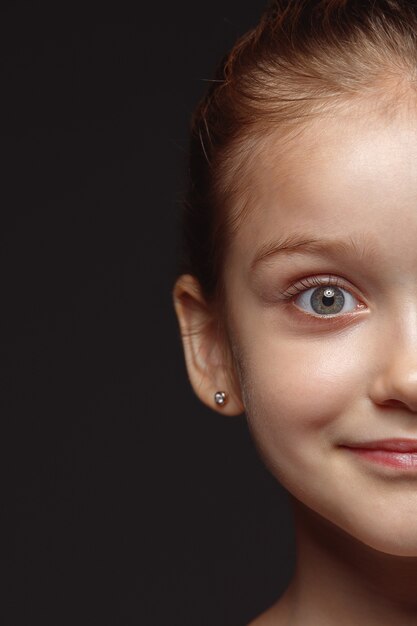 Close up portrait of little and emotional caucasian girl. Highly detail photoshot of female model with well-kept skin and bright facial expression. Concept of human emotions. Calm smiling.