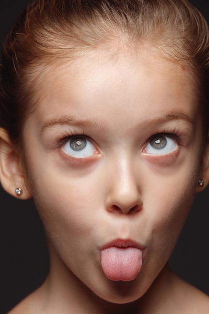 Free Photo close up portrait of little and emotional caucasian girl. highly detail photoshot of female model with well-kept skin and bright facial expression. concept of human emotions. playful gremaces.