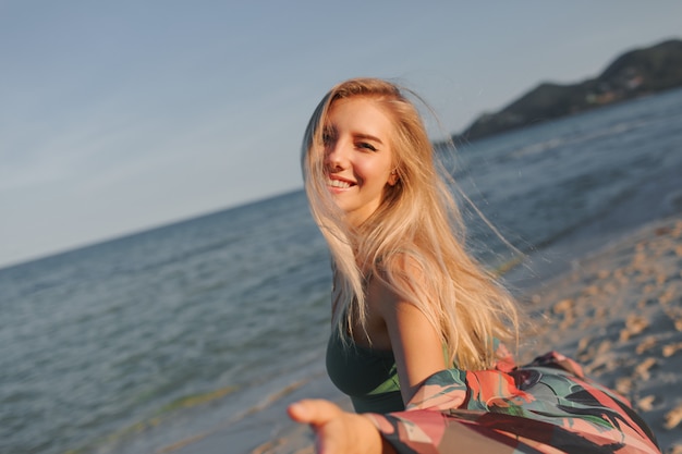 Free photo close up portrait of lovely blond european woman walking on the beach.