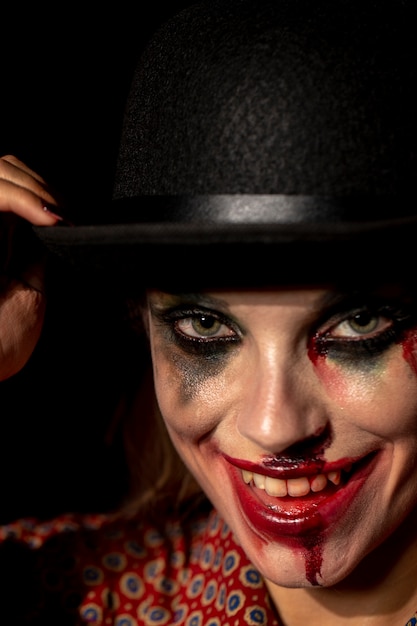 Close-up portrait of make-up woman clown looking at camera